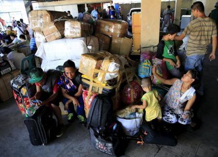 Filipinas evacuó a miles de personas el sábado en la zona noreste de la principal isla del país, Luzón, a menos de 24 horas de que un potente tifón toque tierra, según lo esperado. En la imagen, pasajeros guardan sus pertenencias mientras esperan en una terminal de bus de Manila tras ser evacuados, el 9 de mayo de 2015. REUTERS/Romeo Ranoco